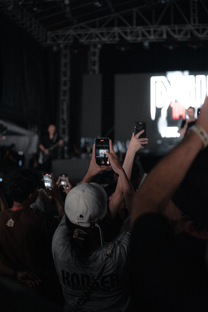 Captivating concert scene with audience recording performances using smartphones.