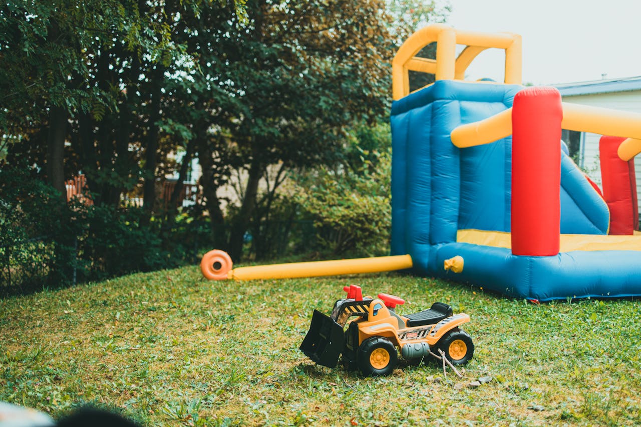 Fun backyard play setup with inflatable structure and toy truck perfect for kids' recreation.