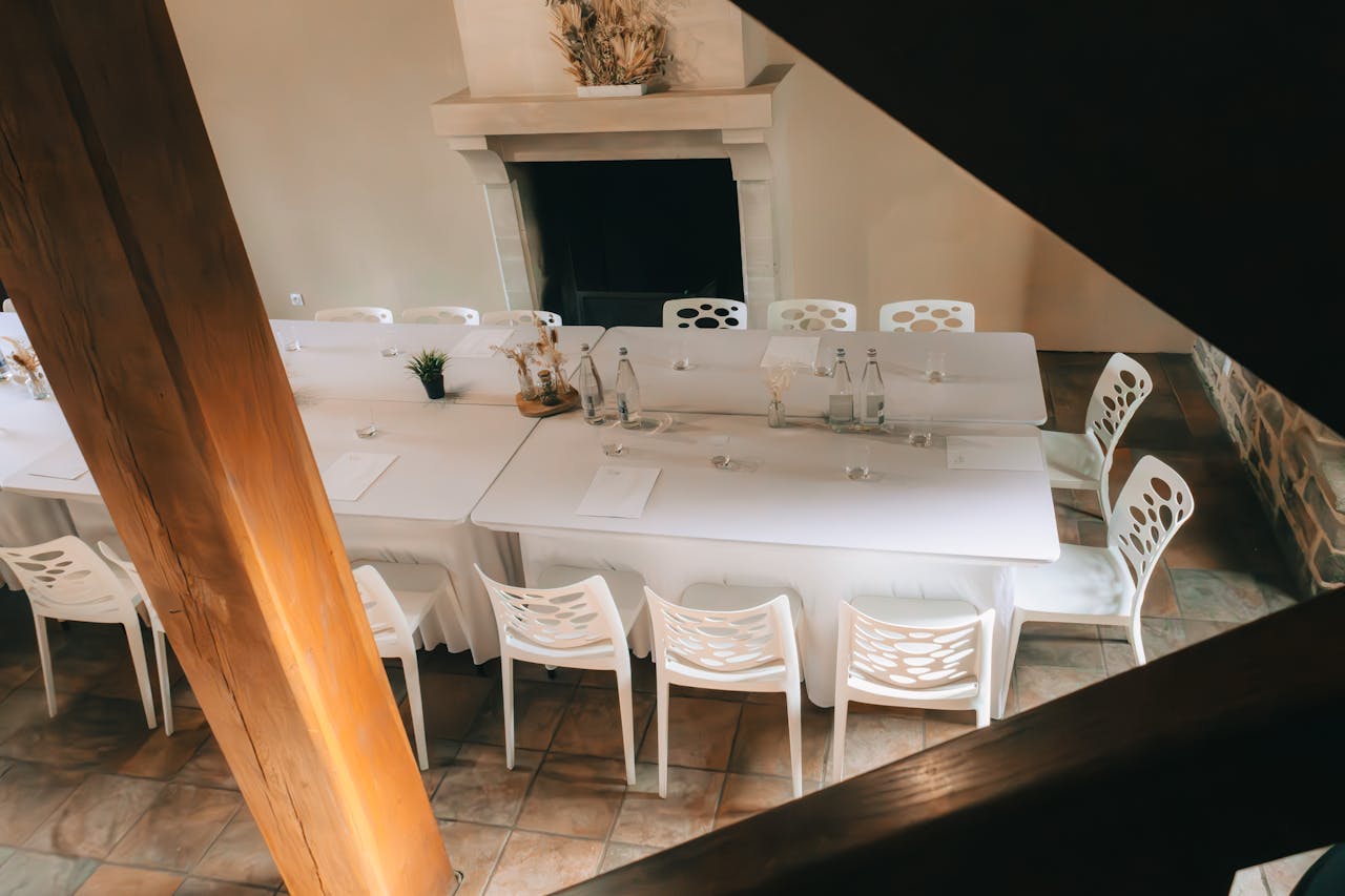 A beautifully arranged conference or meeting room with white tables and chairs, perfect for events.
