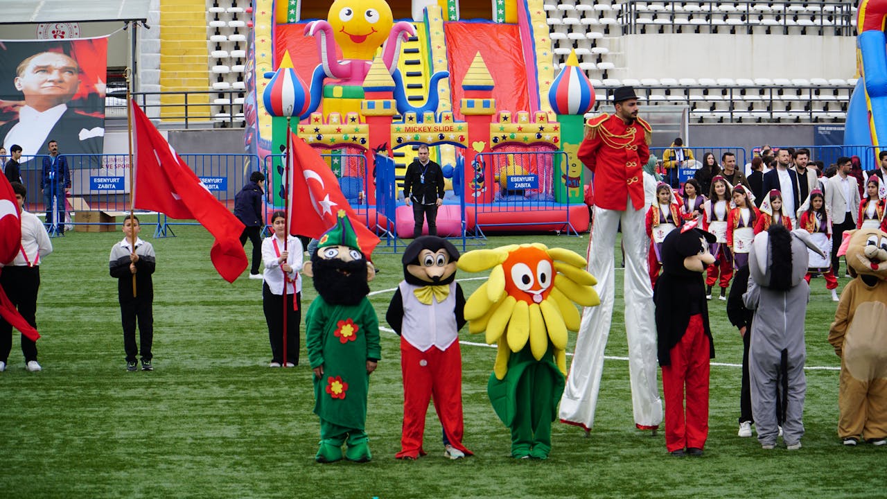 Vibrant celebration of Children's Festival with costumes and flags in İstanbul stadium.